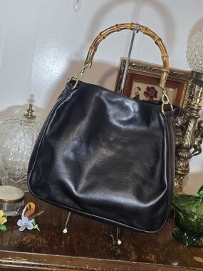 Vintage Gucci black leather hobo bag features the iconic curved bamboo handle.